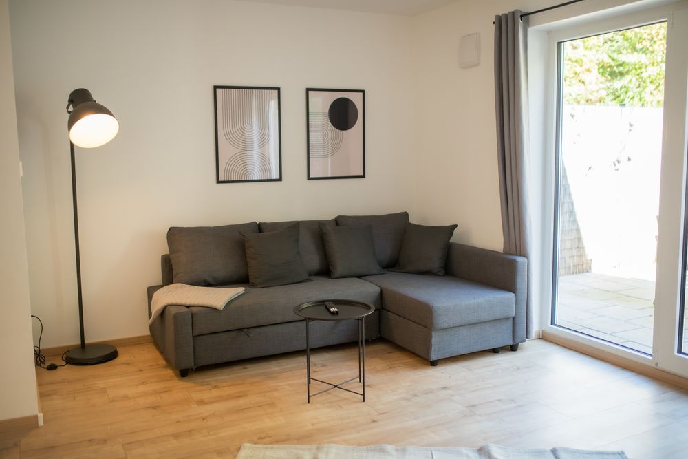Wohnzimmer mit Ecksofa und Terrassentür