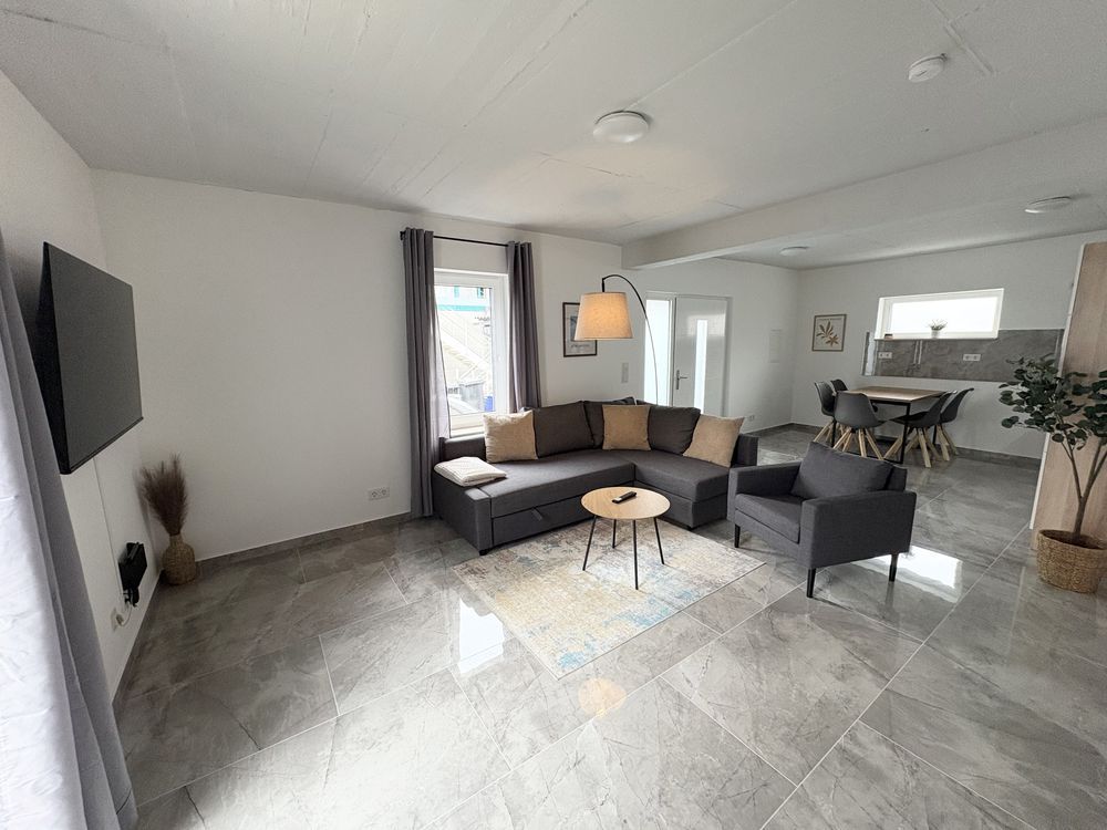 Wohnzimmer mit Ecksofa und Sessel