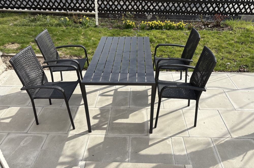 Sonnige Terrasse mit Gartentisch und Rasen