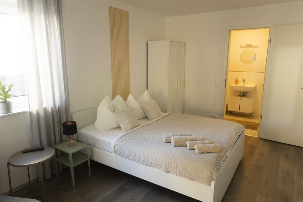 Queensize-Bett mit Blick ins Bad