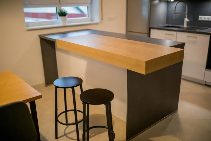Kochinsel mit Holz-Bartheke und Barhockern