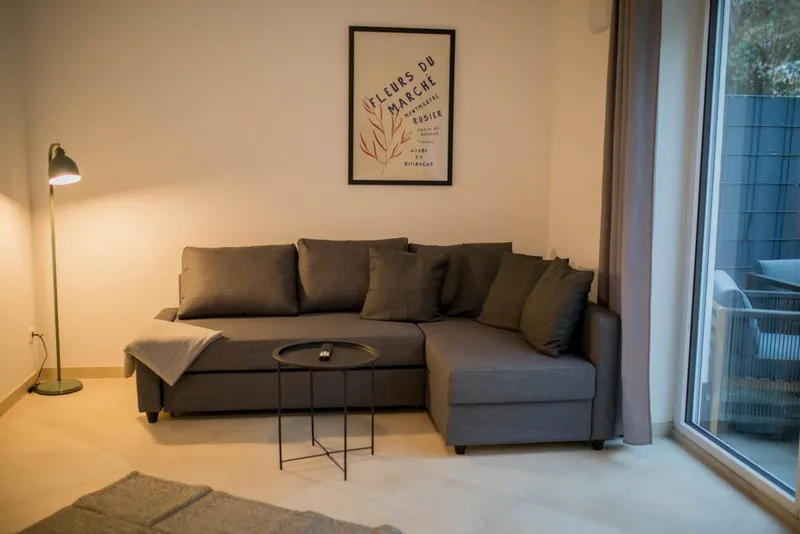 Wohnzimmer mit Ecksofa und Stehleuchte