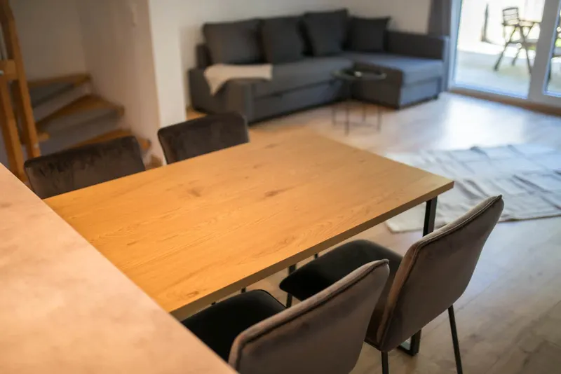 Esstisch, dahinter Wohnzimmer mit Ecksofa