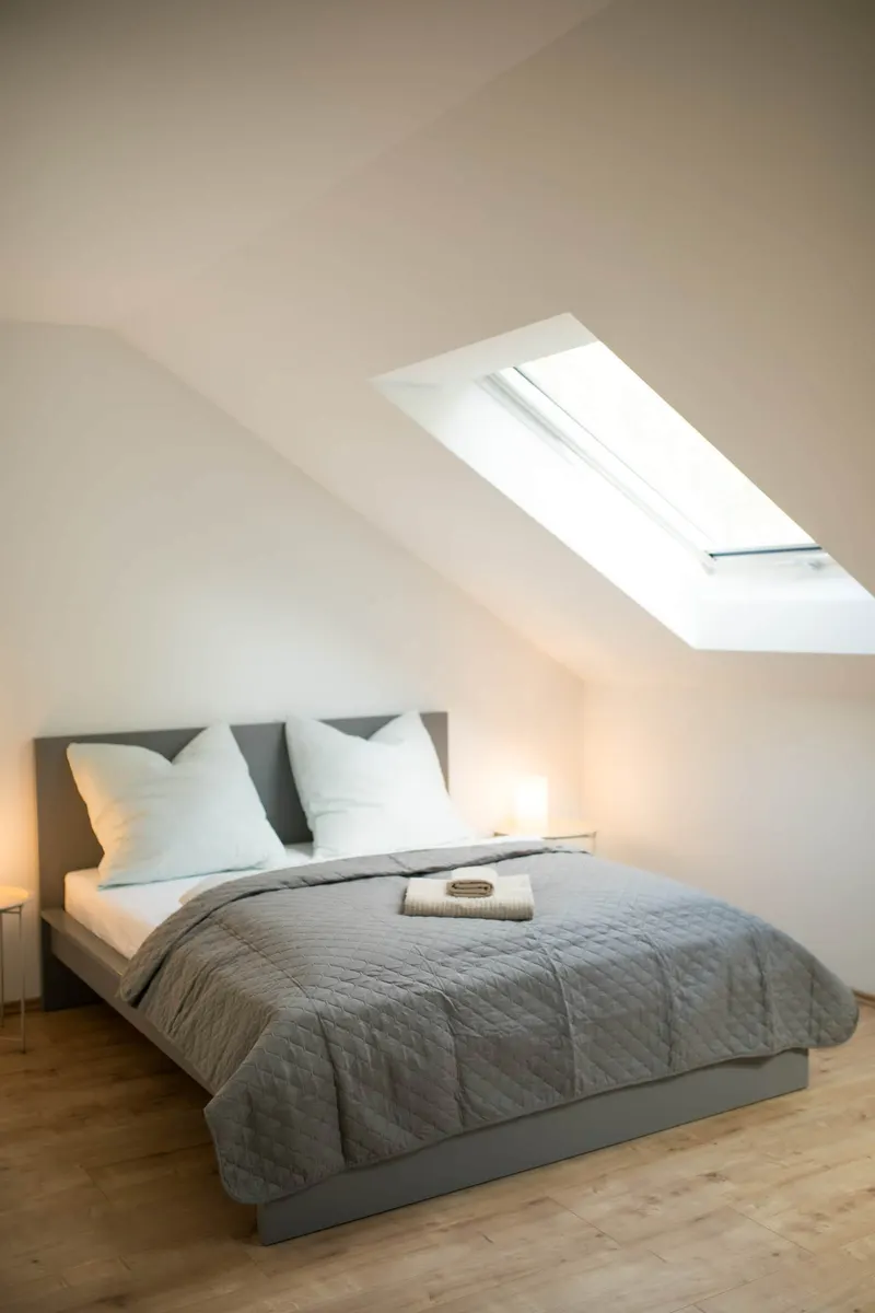 Doppelbett unter dem Dachfenster
