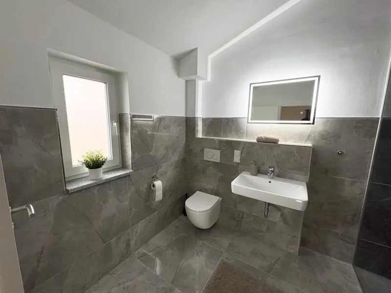 Bad mit Waschbecken, Spiegel und Fenster