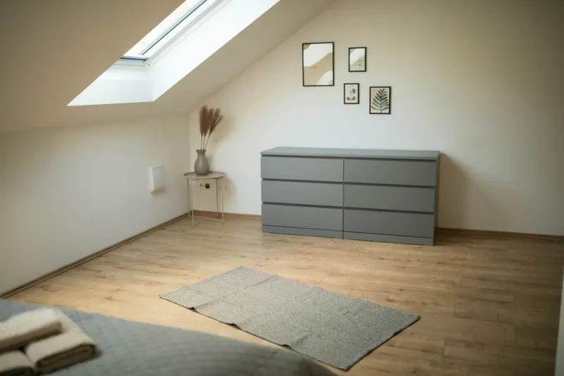 Schlafzimmer unterm Dach mit Kommode und Dachfenster