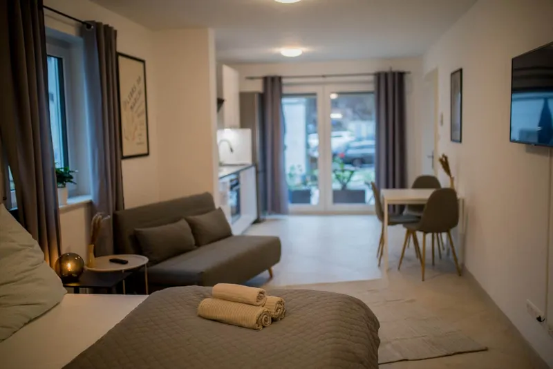 Blick vom Bett über Schlafsofa und Essplatz zur Terrassentür
