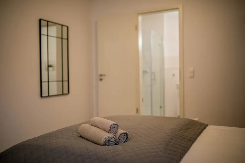 Doppelbett mit Blick zur Tür ins Bad