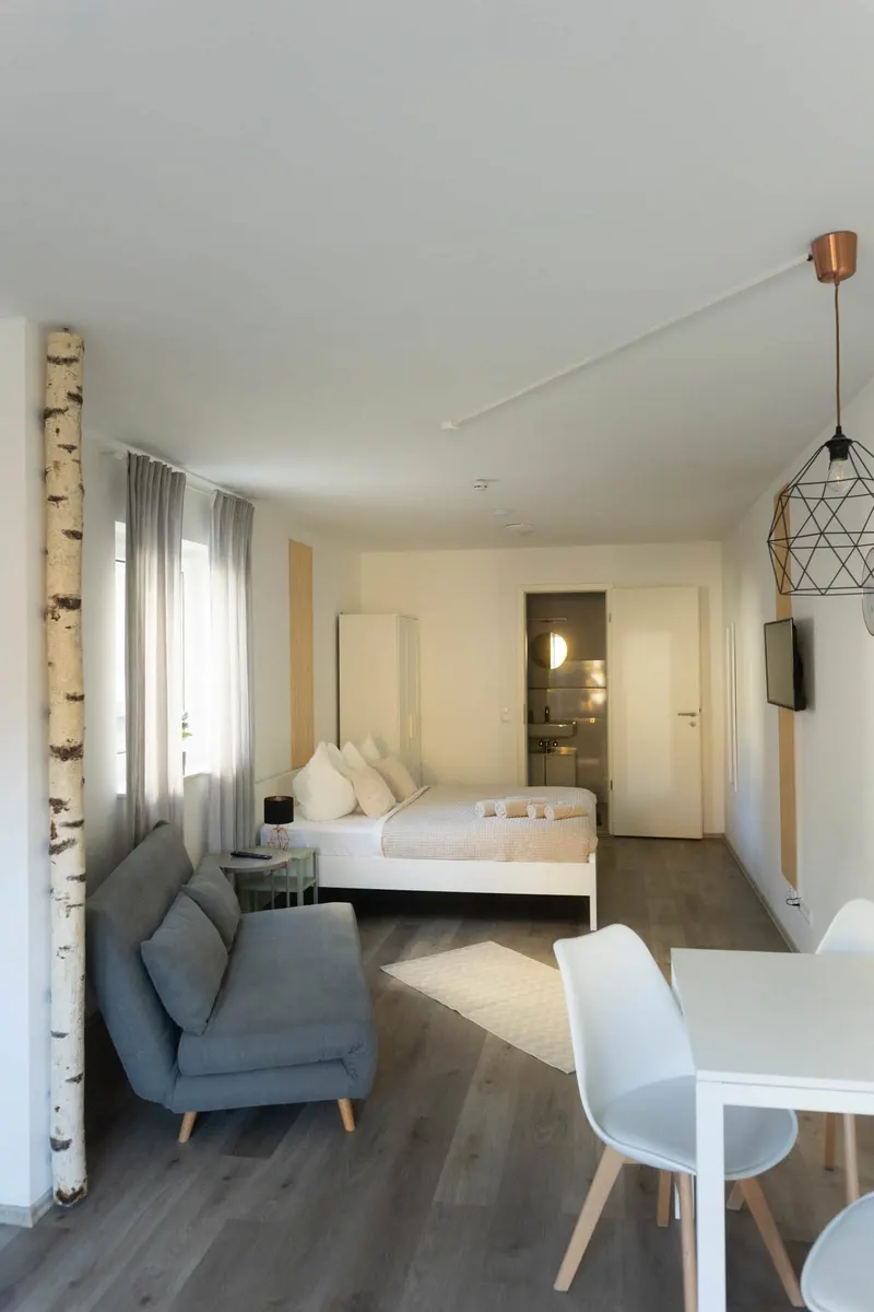 Schlafbereich mit Doppelbett und Blick ins Bad
