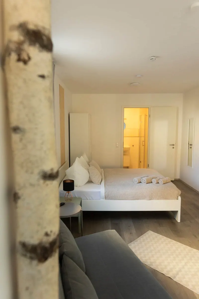 Doppelbett, im Hintergrund die Tür zum Bad