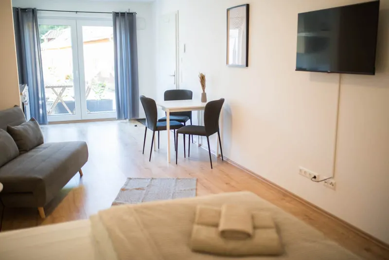 Blick vom Bett zu Essplatz, Smart-TV und Terrassentür
