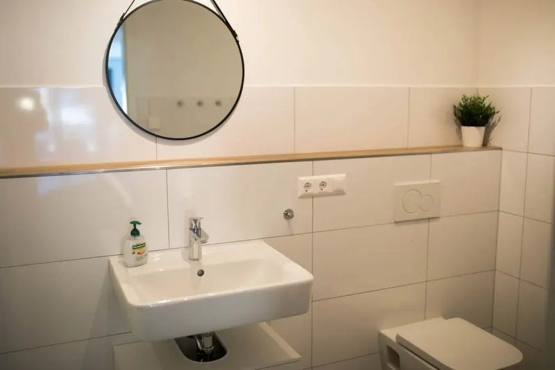 Bad mit Waschbecken und rundem Spiegel