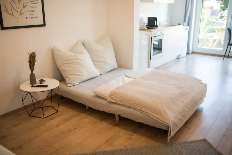 Schlafsofa als Bett, im Hintergrund die Küchenzeile